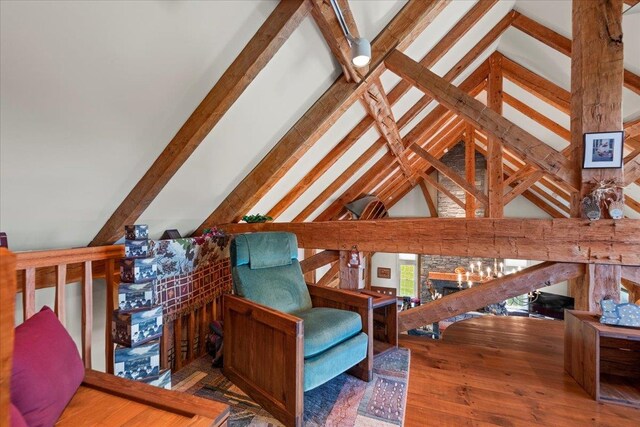 sitting room with vaulted ceiling with beams, a fireplace, and hardwood / wood-style flooring