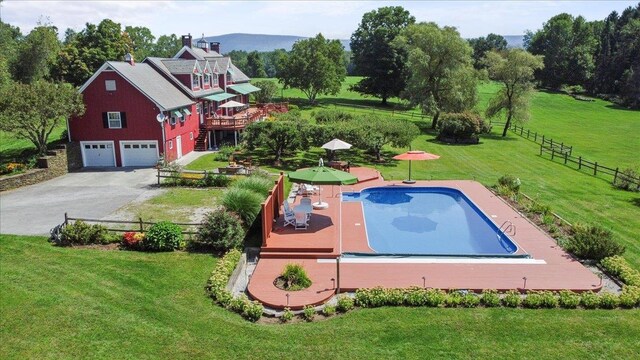 view of swimming pool featuring a wooden deck and a lawn