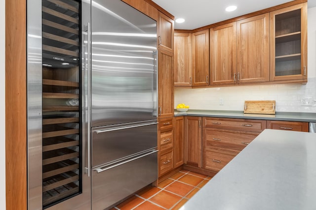 kitchen with built in refrigerator, wine cooler, light tile patterned floors, and tasteful backsplash