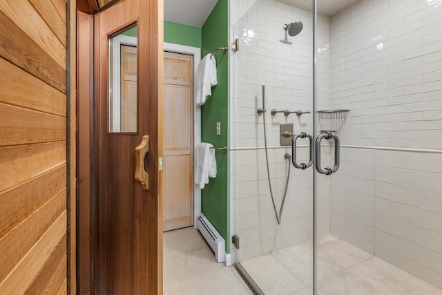 bathroom featuring a baseboard heating unit and a shower with shower door