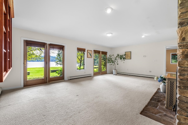 unfurnished living room with dark carpet and baseboard heating