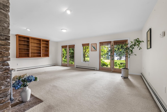 unfurnished living room featuring carpet floors and a baseboard heating unit