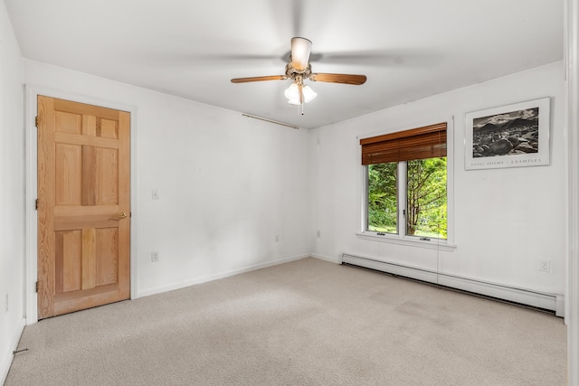 spare room featuring ceiling fan, a baseboard heating unit, and light carpet