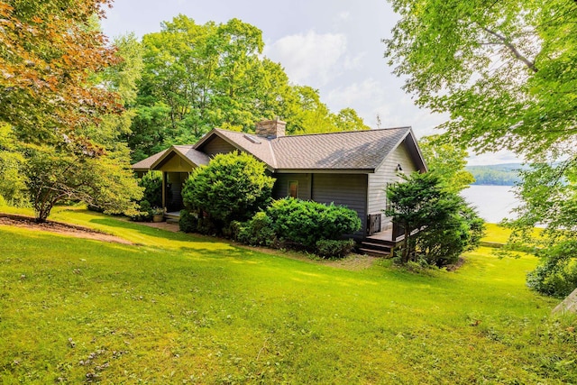 exterior space featuring a water view and a lawn