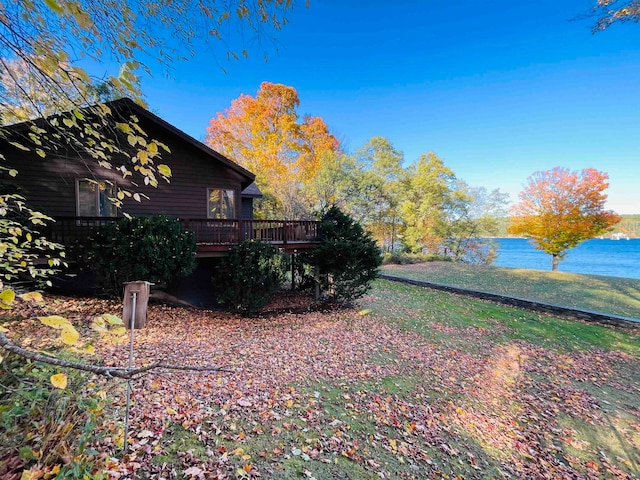 view of yard with a deck with water view