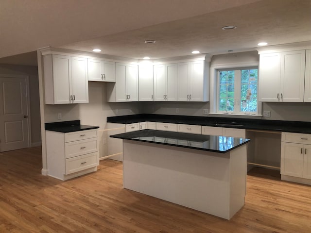 kitchen featuring a center island, sink, white cabinets, and light hardwood / wood-style floors