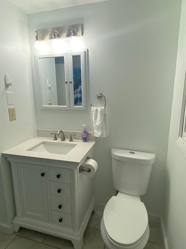 bathroom with tile patterned flooring, vanity, and toilet