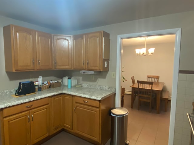 kitchen with light tile patterned flooring, baseboard heating, hanging light fixtures, and a chandelier