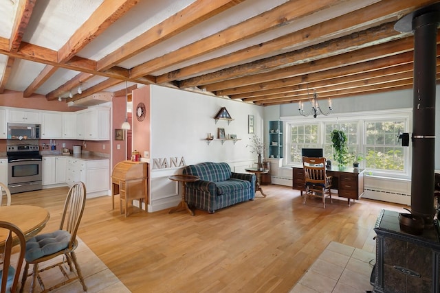 living room with beamed ceiling, a baseboard radiator, light wood-type flooring, and a wood stove