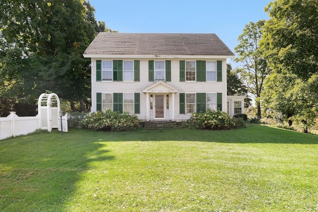 colonial-style house featuring a front yard