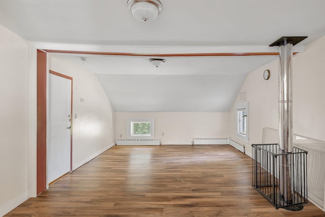 bonus room with radiator, lofted ceiling, hardwood / wood-style floors, and a baseboard heating unit