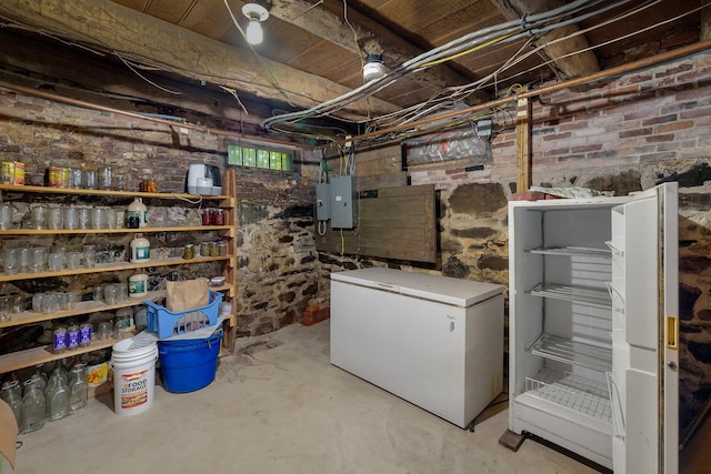 basement featuring white refrigerator and electric panel