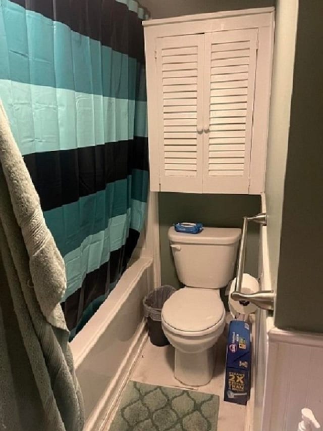 bathroom featuring shower / bath combination with curtain, tile patterned floors, and toilet