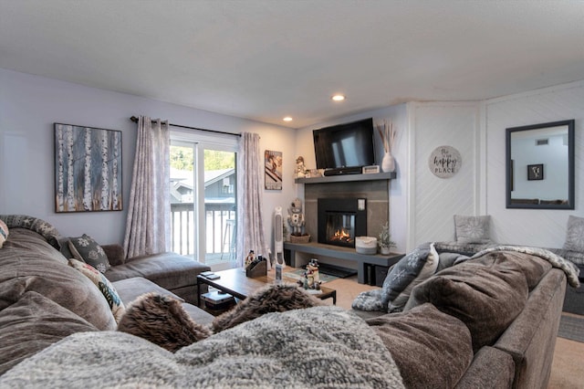 living area featuring a glass covered fireplace, recessed lighting, and carpet floors