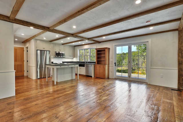 kitchen featuring a kitchen island, a breakfast bar, white cabinetry, light hardwood / wood-style floors, and stainless steel appliances