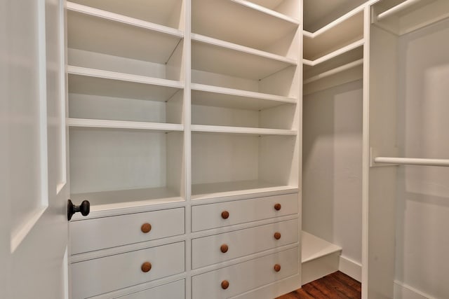 walk in closet with dark wood-type flooring