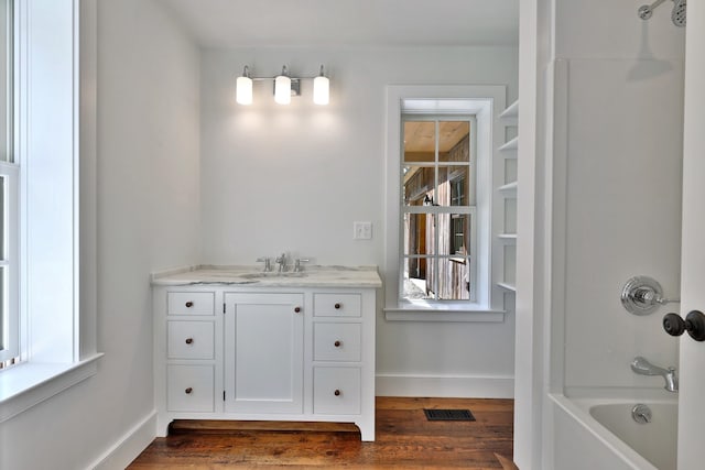 bathroom featuring shower / bathtub combination, vanity, and hardwood / wood-style floors