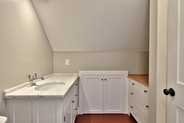 bathroom with lofted ceiling and vanity