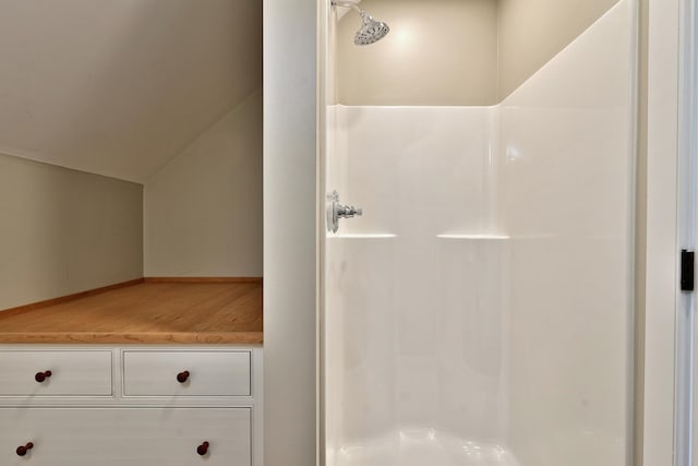 bathroom with lofted ceiling and a shower