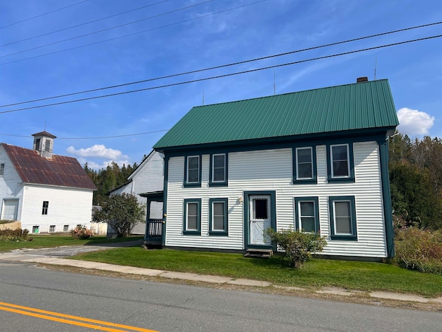 colonial-style house featuring a front lawn