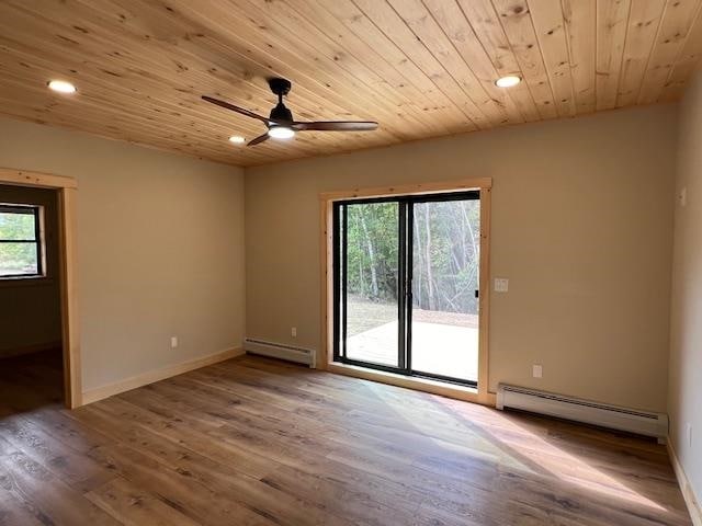 empty room with ceiling fan, hardwood / wood-style floors, a baseboard radiator, and wooden ceiling