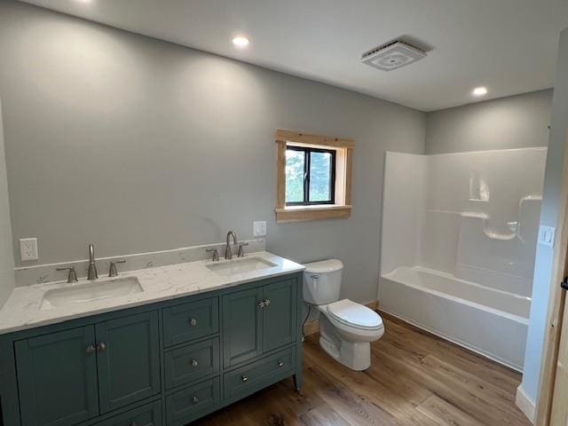 full bathroom with vanity, toilet, wood-type flooring, and washtub / shower combination