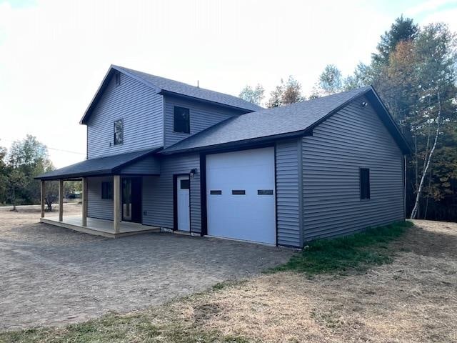 exterior space with covered porch and a garage