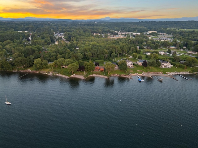 aerial view at dusk featuring a water view