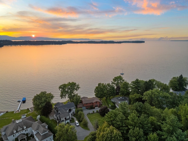 aerial view at dusk featuring a water view