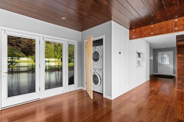 clothes washing area with wood ceiling, hardwood / wood-style flooring, and stacked washer and clothes dryer