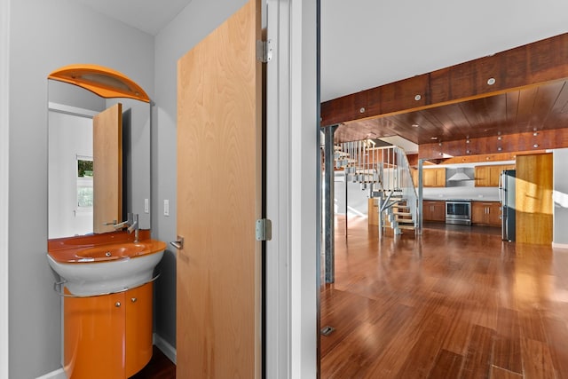 hallway with sink, dark wood-type flooring, and wooden ceiling