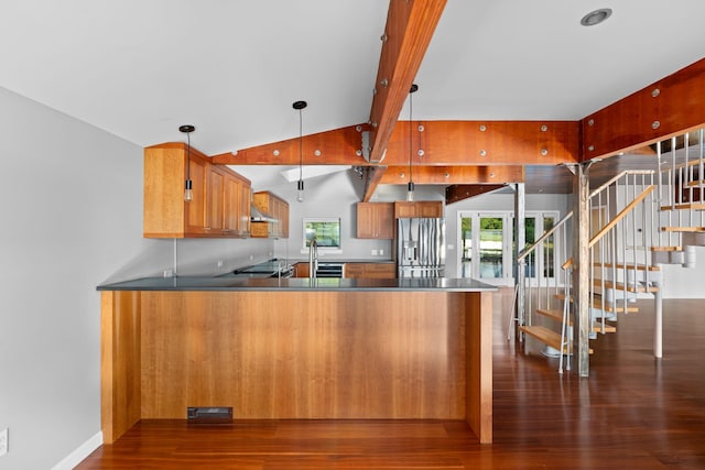 kitchen featuring kitchen peninsula, pendant lighting, lofted ceiling, stainless steel refrigerator with ice dispenser, and dark hardwood / wood-style floors