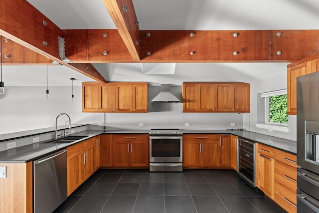 kitchen with appliances with stainless steel finishes, wine cooler, dark tile patterned floors, sink, and wall chimney range hood