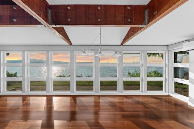 unfurnished sunroom with an inviting chandelier, beam ceiling, and a water view