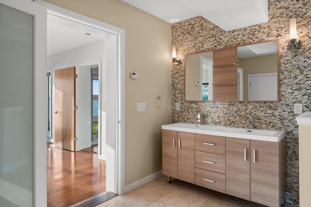 bathroom with wood-type flooring, vanity, and tasteful backsplash