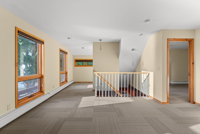 corridor with baseboard heating and carpet flooring