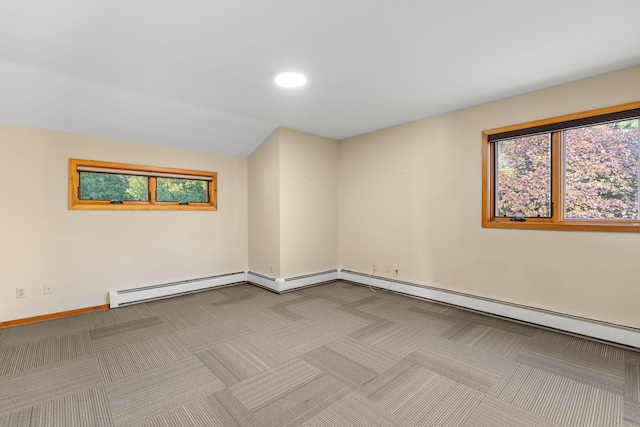 spare room featuring a baseboard heating unit and light carpet