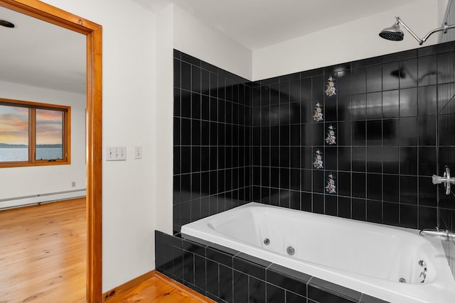 bathroom with wood-type flooring, a baseboard radiator, and tiled shower / bath combo