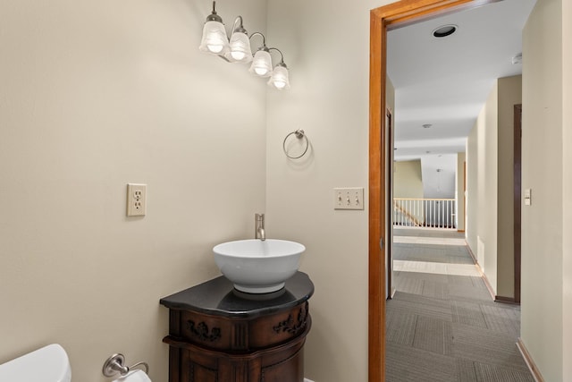 bathroom with vanity, toilet, and a notable chandelier