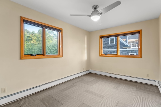 carpeted spare room featuring a baseboard heating unit and ceiling fan