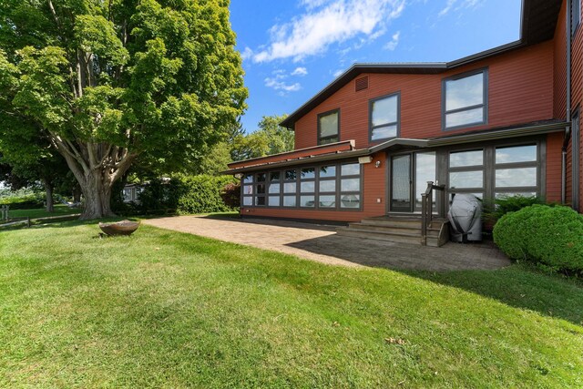 rear view of property featuring a yard