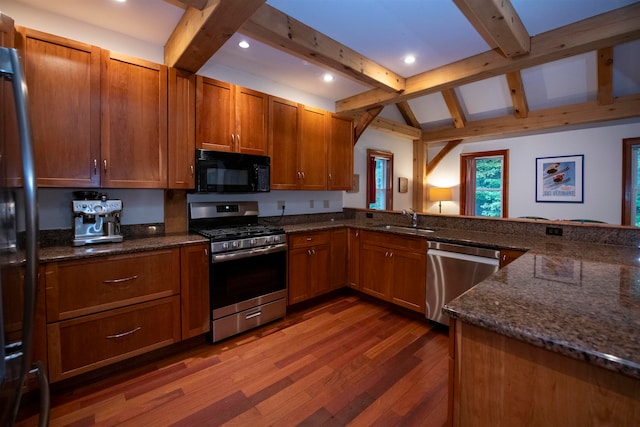 kitchen with kitchen peninsula, sink, stainless steel appliances, and hardwood / wood-style flooring