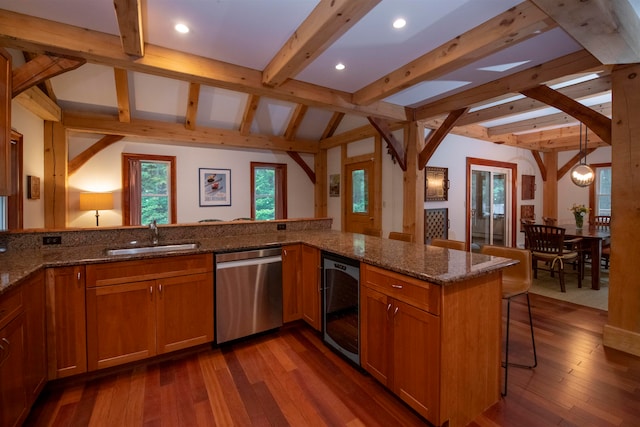 kitchen with dark stone counters, sink, kitchen peninsula, and stainless steel dishwasher