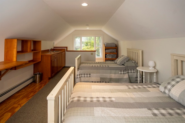 bedroom with hardwood / wood-style floors, vaulted ceiling, sink, and a baseboard heating unit