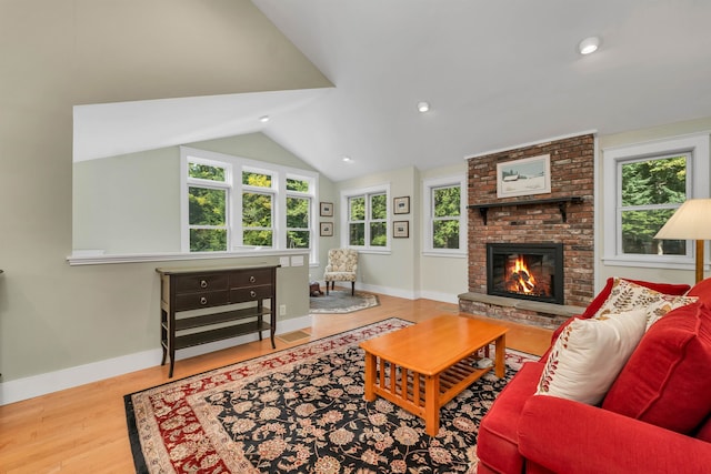 living room with light hardwood / wood-style floors, a fireplace, and lofted ceiling