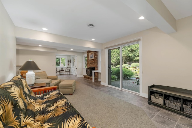 living room with a healthy amount of sunlight, a fireplace, and light colored carpet