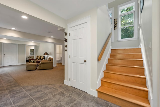 stairway featuring carpet flooring