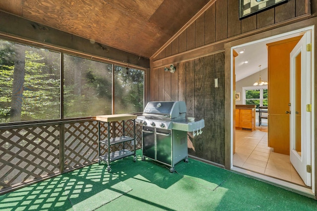 sunroom / solarium featuring an inviting chandelier and lofted ceiling