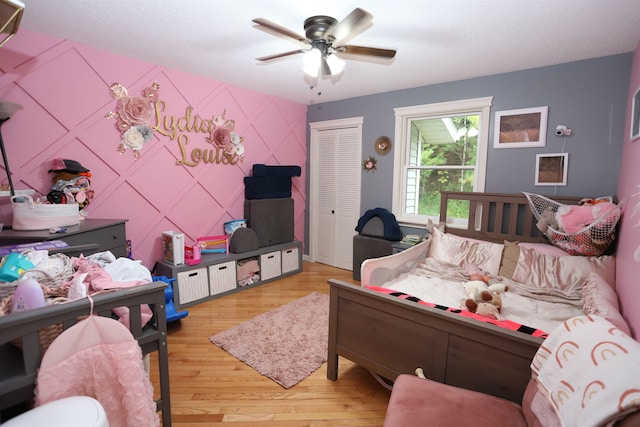 bedroom with a closet, light hardwood / wood-style floors, and ceiling fan