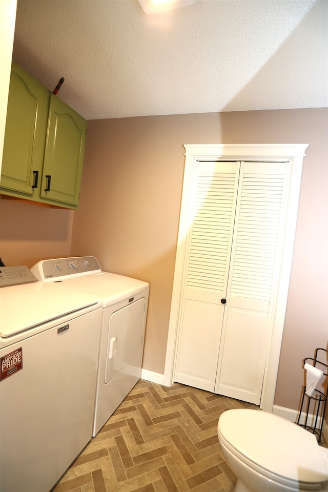 laundry room with a textured ceiling, parquet flooring, and washing machine and clothes dryer